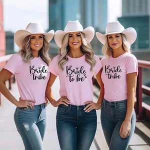 Outdoor shot of three women in pink Bride Tribe cotton t-shirts with bridal cowboy hats