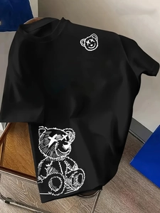 Close-up of white graffiti bear print with X-eyes on black cotton t-shirt streetwear