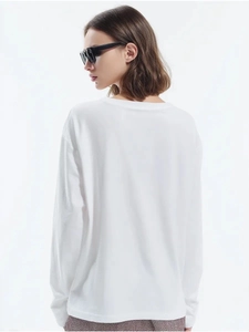 Detail shot of the back of a white long-sleeve cotton T-shirt showing minimalist cut