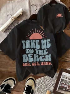 Détail du t-shirt noir ample en coton avec imprimé coucher de soleil rétro et texte de plage