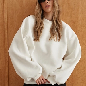 Detailed close-up of a white oversized crewneck sweatshirt with dropped shoulders