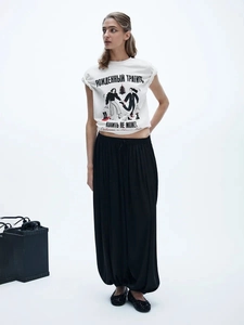 Detail of white cotton T-shirt with Russian print and black wide-leg trousers outfit