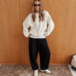 Minimalist white oversized crewneck sweatshirt and black wide-leg trousers set on model