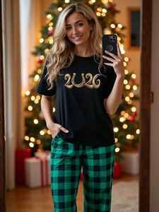 Detail of 2026 printed black cotton T-shirt with green plaid festive pajama pants