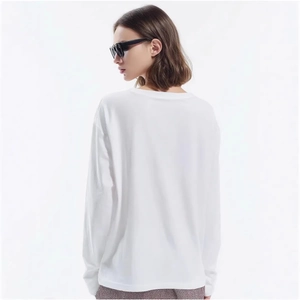 Back view of a white loose-fit long sleeve cotton T-shirt with a stylish drop shoulder design
