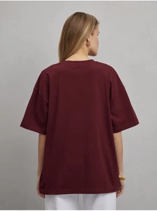Vue arrière d'un t-shirt oversize en coton bordeaux avec design à épaules tombantes
