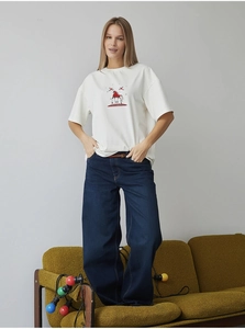 Detail of pure white cotton T-shirt featuring a red horse art print and star patterns