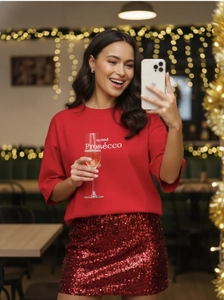 Detail of red festive set with Good Prosecco sweatshirt and matching sequin skirt