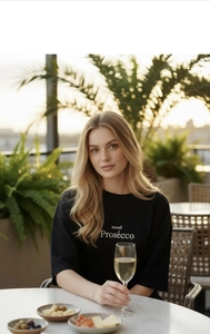 Gros plan extérieur d'un t-shirt en coton noir oversize avec imprimé mood Prosecco blanc