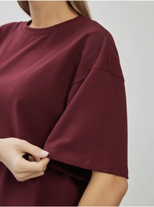 Gros plan détaillé sur les coutures doubles d'un t-shirt en coton bordeaux