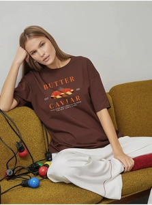 Detail of butter caviar print on oversized dark brown cotton T-shirt worn by model