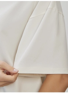 Close-up of cream cotton T-shirt featuring high-density knit fabric and double-needle stitching