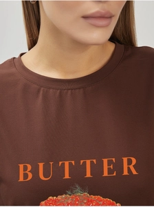 Detail of soft cotton T-shirt featuring BUTTER typography and realistic berry print