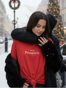 Detail of red mood prosecco tee with front knot design in festive outdoor scene
