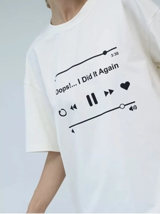 Detailed close-up of a white cotton t-shirt featuring a black music player interface print