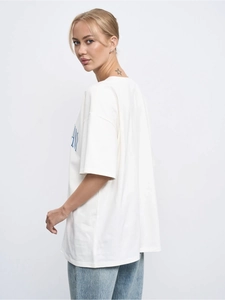 Detail of white cotton oversized T-shirt with blue letter print and crew neck