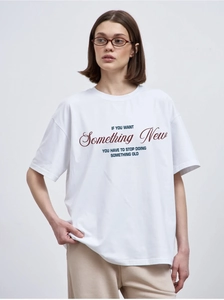 Close-up of white oversized cotton T-shirt featuring motivational typography print