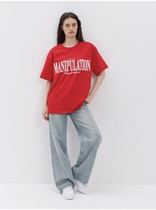Detailed view of red cotton t-shirt featuring bold white typography on a studio model