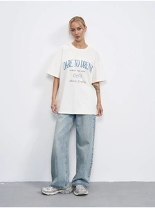 Detail of Dare to Dream letter print on a beige oversized cotton t-shirt