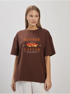 Close-up of butter and caviar aesthetic graphic print on a loose cotton t-shirt