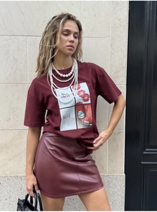 Detail of burgundy T-shirt with vintage mon chéri print and red leather skirt