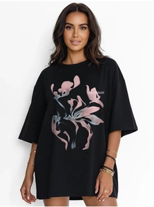 Détail d'un t-shirt noir oversize en coton avec motif graphique abstrait rose et bleu