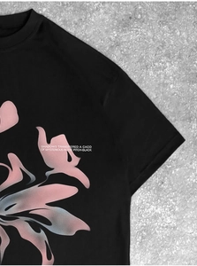 Détail du graphique dégradé rose et bleu avec typographie sur le T-shirt en coton noir