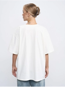 Back view of a loose fit white cotton T-shirt with drop shoulders on a model