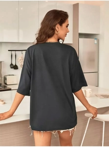 Detail view of oversized black heart print t-shirt in a cozy modern kitchen setting