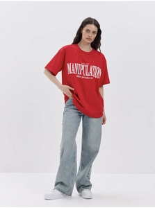 Detail of red cotton oversized T-shirt with white manipulation slogan print design