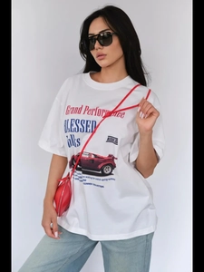 Dettaglio di una t-shirt bianca in cotone con stampa di auto da corsa rossa e scritte
