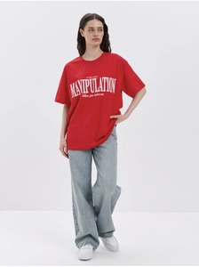 Detail of red cotton T-shirt featuring white letter print styled with blue jeans