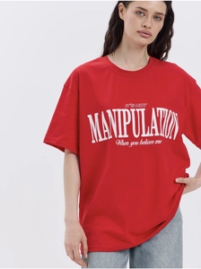 Close-up of white manipulation text print on a red oversized cotton t-shirt