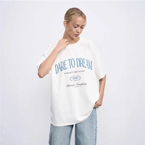 Oversized white cotton T-shirt with Dare to Dream lettering and blue denim jeans