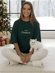 Détail du t-shirt ample vert foncé avec imprimé mood Prosecco dans un décor d'hiver douillet