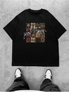 T-shirt noir en coton avec imprimé floral ethnique coloré posé à plat sur le sol