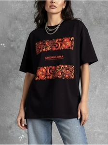 Dettaglio della stampa Khokhloma su t-shirt nera in cotone con collana e jeans blu