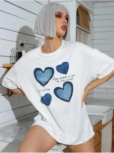 Detail view of the soft cotton white T-shirt featuring blue denim-style heart prints