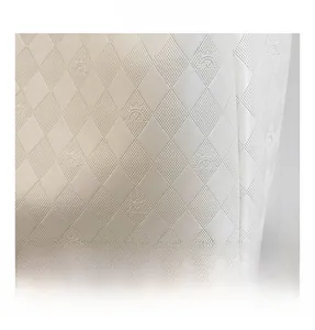 Close-up of beige faux leather with embossed crown and M logo pattern on tote bag