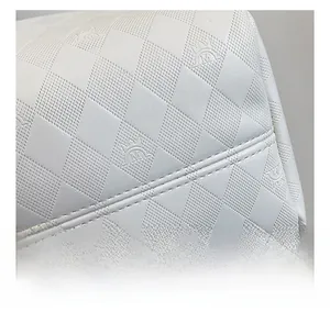 Macro shot of white leather texture with embossed crown logo and diamond pattern detail