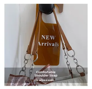 Detail showing white quilted tote bag with brown leather and silver chain shoulder straps