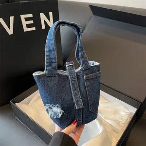 Sac seau en denim bleu élégant avec détails vintage usés et sangle à boucle métal