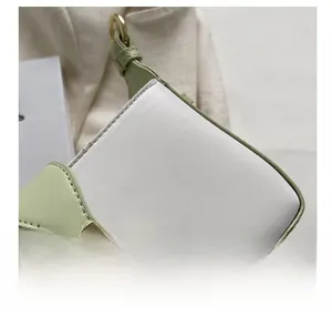 Détail du sac en cuir blanc et vert menthe avec coutures précises et boucle en métal doré