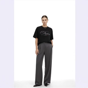 T-shirt chic in cotone nero Prosecco da donna con pantaloni grigi larghi a vita alta