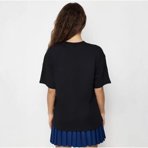Vue arrière d'un t-shirt en coton noir avec imprimé LOVE et jupe plissée bleue