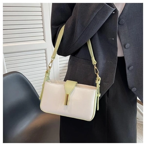 Sac bandoulière crème et vert citron porté avec un blazer gris et boucle dorée