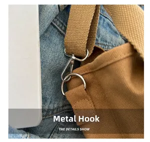Detailed close-up of the silver metal swivel hook and D-ring on the brown canvas bag