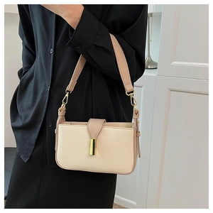 Détail d'un sac à bandoulière beige minimaliste avec fermoir doré sur la sangle