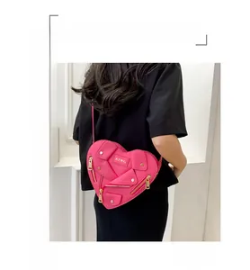 Dettaglio della borsa rosa a forma di cuore con cerniere e borchie in stile motociclista