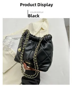Detail of black quilted chain bucket bag with gold ball charm and drawstring closure